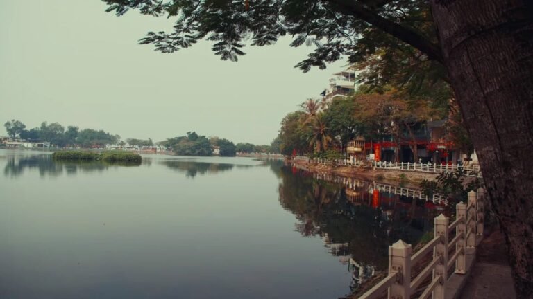 Tree-lined lakeside promenade in Vietnam at dusk