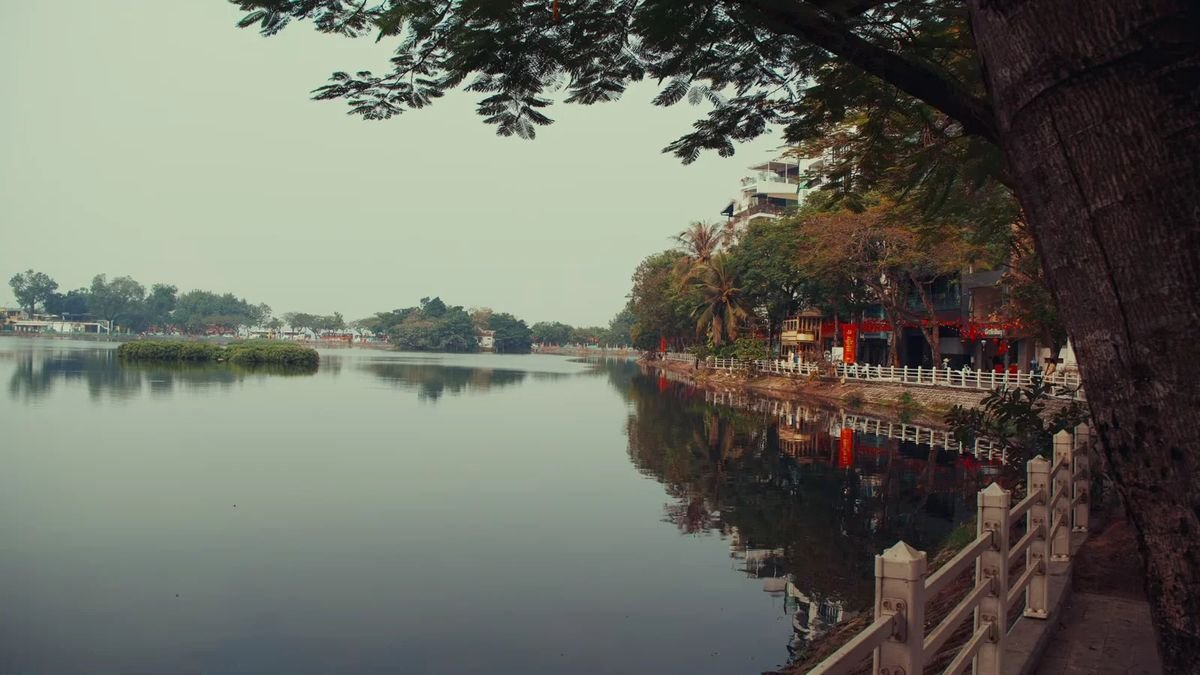Tree-lined lakeside promenade in Vietnam at dusk