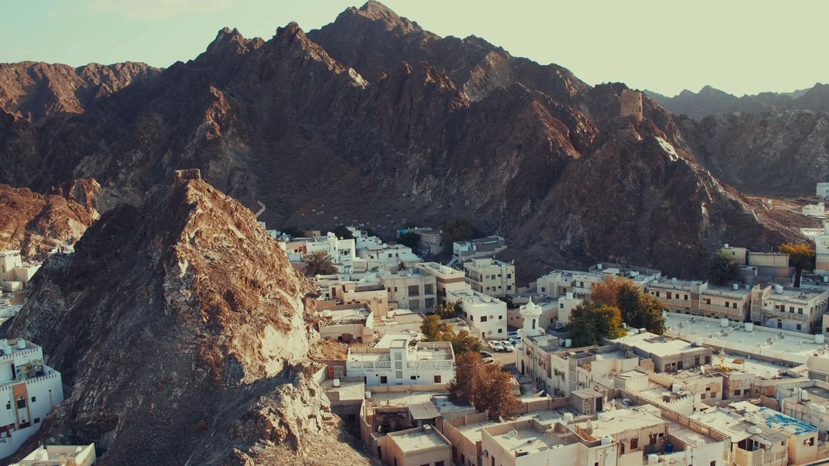 Whitewashed town beneath rugged mountains, Oman