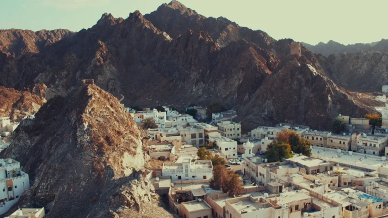Whitewashed town beneath rugged mountains, Oman